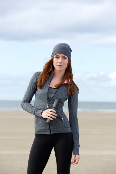 Sporty woman standing outdoors with water bottle - Photo, Image