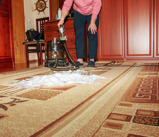 Prosessi puhdistus matto pölynimurilla vedellä suodatin. Nainen soveltaa puhdistus vaahto likainen matto pinta. - Valokuva, kuva