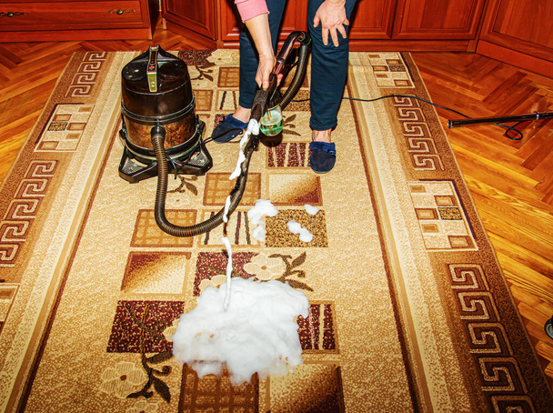 Prosessi puhdistus matto pölynimurilla vedellä suodatin. Nainen soveltaa puhdistus vaahto likainen matto pinta. - Valokuva, kuva