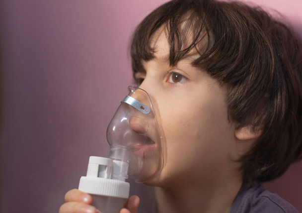 the child does inhalation, the boy inhales the medicine through the mask, nebulizer mask, treatment of the disease - Foto, Imagen