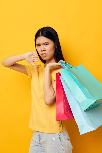 woman with Asian appearance woman with packages in hands shopping isolated background unaltered - Foto, immagini