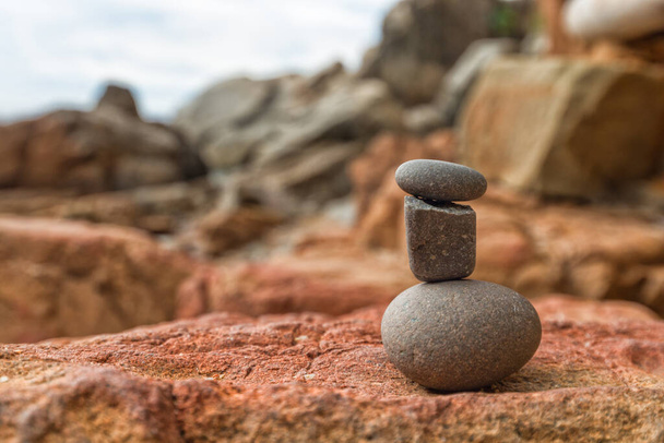 three stones in a stack near the sea on the beach. ideological concept. - Photo, Image