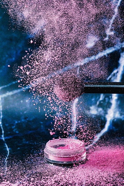 Maquillaje de cepillos cosméticos con una explosión de colorete en polvo sobre un hermoso fondo. Cuidado de la piel o concepto de moda - Foto, imagen