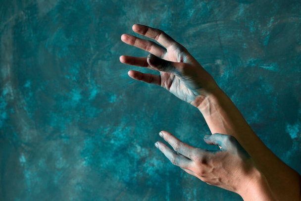 Жіночі руки зафарбовані синьою фарбою на синій стіні
 - Фото, зображення