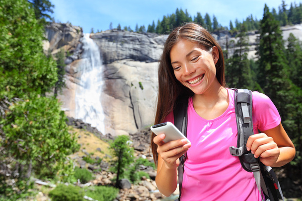 Woman hiker using smartphone app on travel - Foto, Imagen