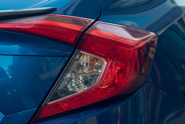 Vista macro de la luz trasera de la lámpara de xenón del coche azul moderno, parachoques, tapa trasera del maletero. Exterior de una ca moderna - Foto, imagen