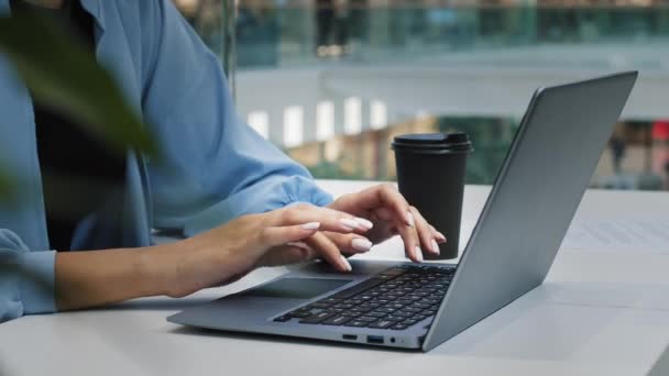 Onherkenbare zakenvrouw in blauw shirt in cafe op kantoor met koffie thee typen laptop close-up vrouwelijke handen werk sms-en chat online internet support service e-learning computer app winkelen - Video