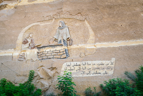 Τοιχογραφία και στίχος Αγία Γραφή, Ιωάννης 4: 13-14, Χαραγμένο σε έναν τοίχο στο Saint Samaan Η Μονή Tanner, Κάιρο, Αίγυπτος - Φωτογραφία, εικόνα