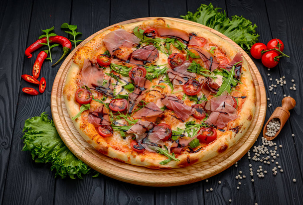 Delicious pizza with prosciutto and arugula. Italian snacks. Top view. - Fotografie, Obrázek