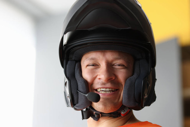 Hombre sonriente en casco de motocicleta con altavoz - Foto, Imagen
