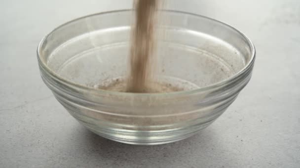 Наполнение стеклянной чаши пищевой добавкой из раковины псиллия - Кадры, видео