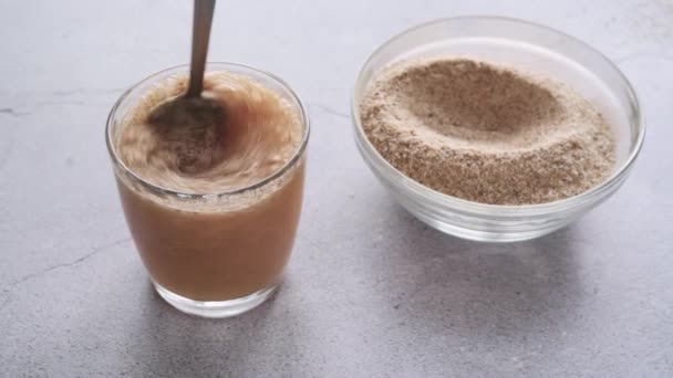 Suplemento dietético de fibra de cáscara de Psyllium mezclado con agua en un vaso - Metraje, vídeo