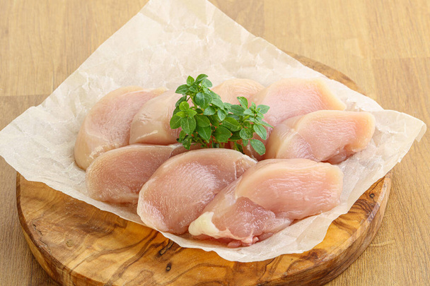 Πρώτες φέτες στήθους κοτόπουλου για μαγείρεμα πάνω από το τραπέζι - Φωτογραφία, εικόνα
