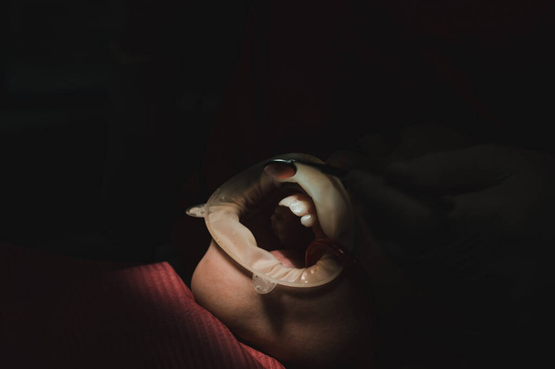 Il bambino si siede su una sedia dentale, espulsore di saliva in bocca, trattamento della carie nel bambino, luce diretta sulla bocca del bambino, riavvolgitore dentale sulle labbra di un ragazzo. - Foto, immagini