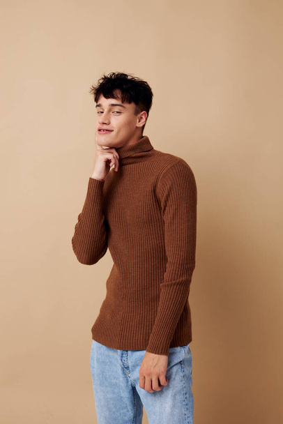A young man posing in brown sweater self confidence fashion light background unaltered - Foto, Imagem