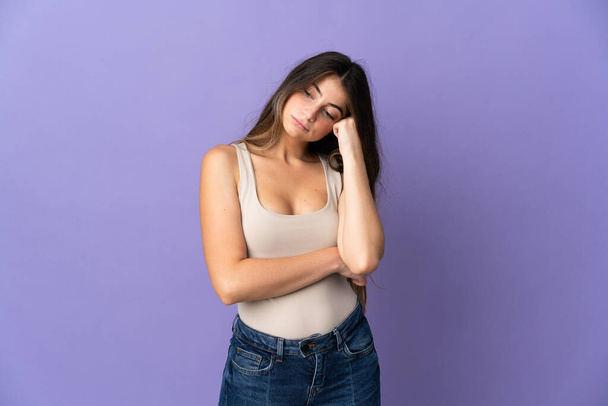 Young caucasian woman isolated on purple background with tired and bored expression - Fotoğraf, Görsel
