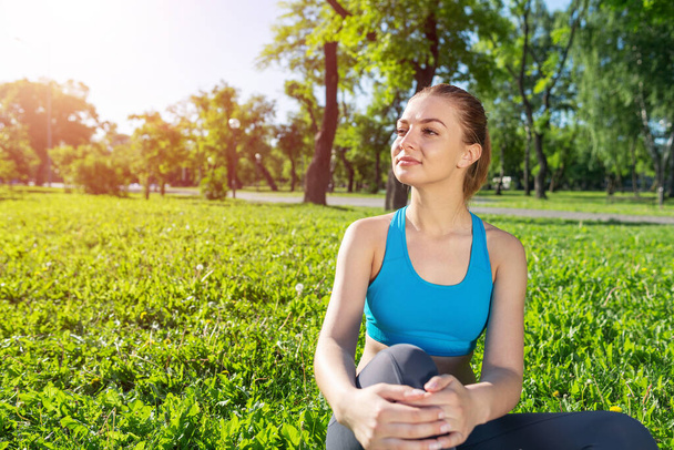 Beautiful smiling girl in sportswear relax in park - Photo, Image
