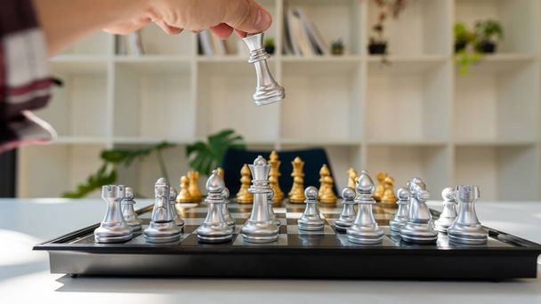 Strategie und Planungskonzepte Nahaufnahme einer menschlichen Hand, die den ersten Zug in einer Partie von Schachkönigen macht. Ein Schwerpunkt vorwärts - Foto, Bild