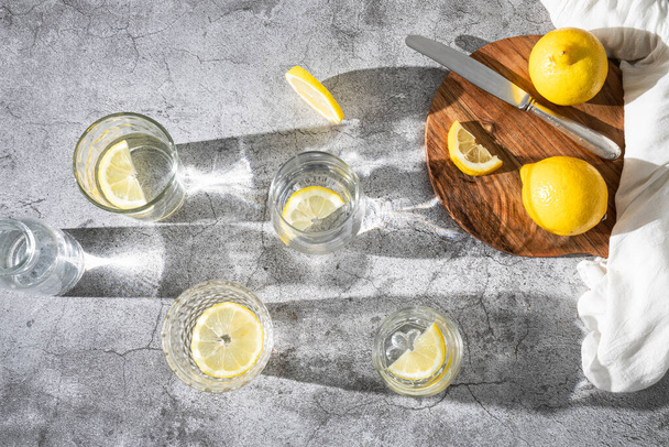 Acqua rinfrescante al limone. Bicchieri con acqua e fette di limone. Bevanda disintossicante - Foto, immagini