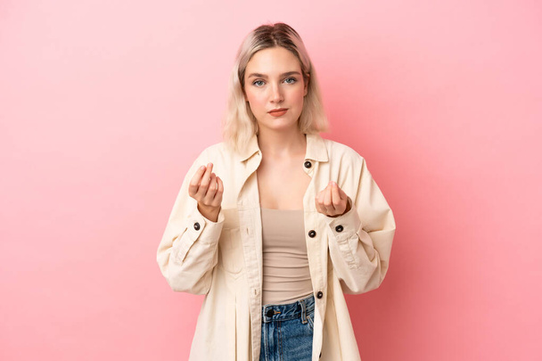 Young caucasian woman isolated on pink background making money gesture but is ruined - Photo, Image