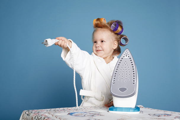 little housewife with iron on blue background - Fotoğraf, Görsel