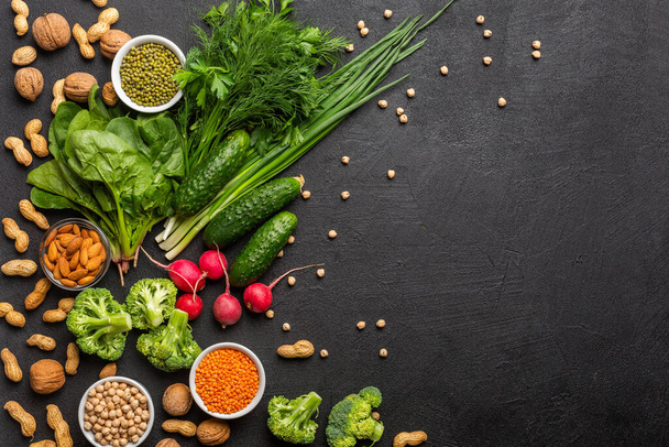 Proteine per vegetariani: tofu, verdure, noci, semi e legumi vista dall'alto su uno sfondo nero. Concetto: cibo sano e pulito. Copia spazio. - Foto, immagini