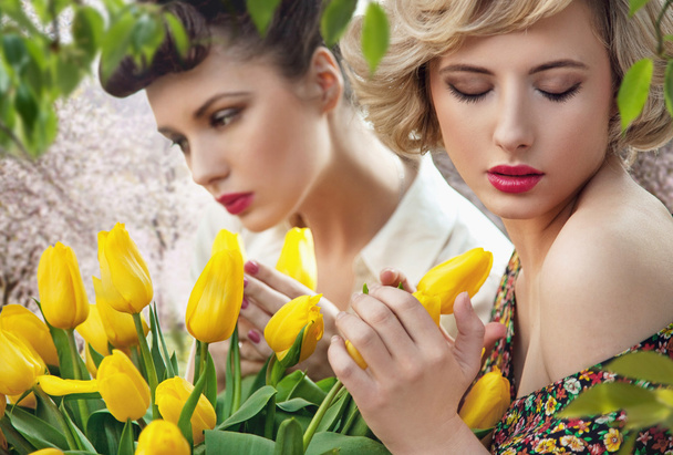 Two beautiful ladies in a tulip garden - Fotografie, Obrázek