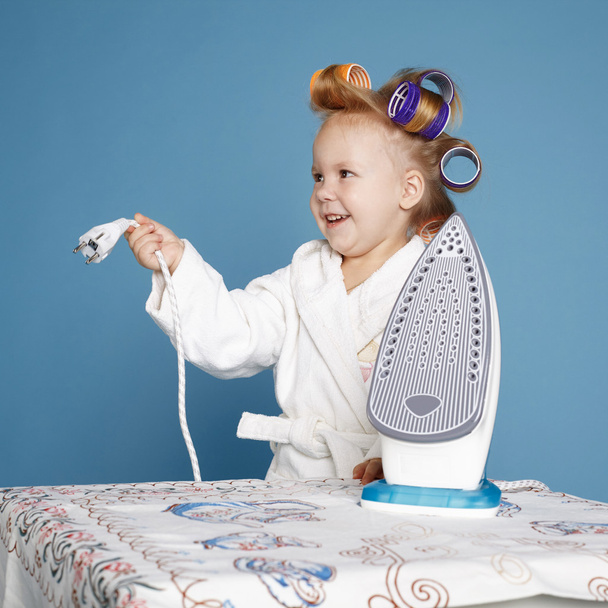 little housewife with iron on blue background - Foto, Imagem