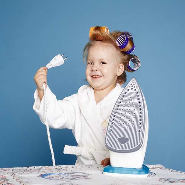 little housewife with iron on blue background - Zdjęcie, obraz