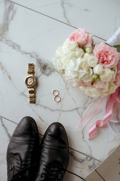 A bridal bouquet of white and pink roses, wedding rings, men's watches and the groom's shoes. wedding details  - Fotoğraf, Görsel