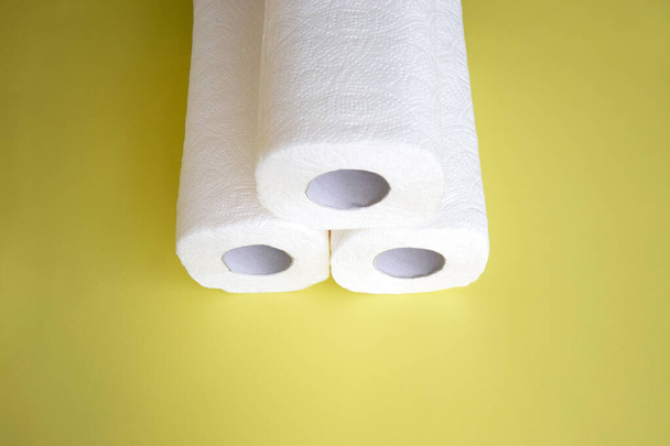 Chłonna papierowa serwetka ręczniki kuchenne na żółtym tle, rolka papieru sanitarnego. - Zdjęcie, obraz