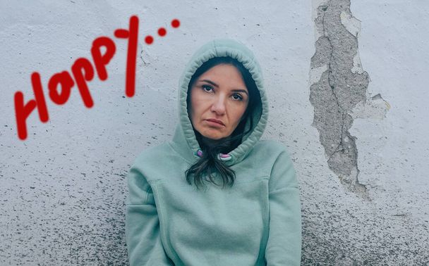 Mujer infeliz y deprimida frente a la pared que dice felicidad - Foto, imagen