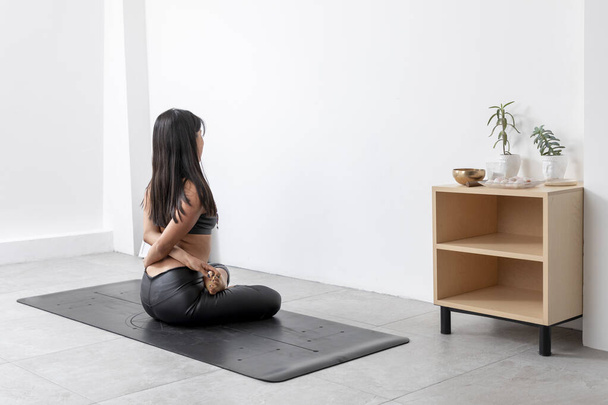 Young Hispanic woman, doing yoga and meditation poses in studio, wearing sportswear. - Photo, Image