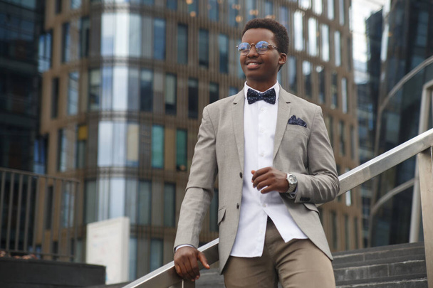 Cute black male businessman on the background of an office building. - Foto, afbeelding