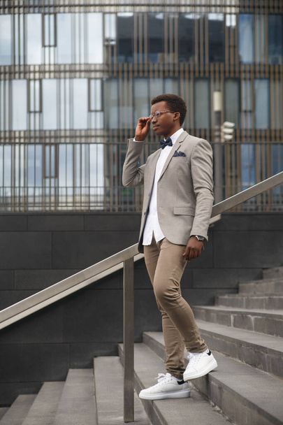 Cute black male businessman on the background of an office building. - Φωτογραφία, εικόνα
