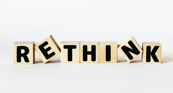 Word Rethink on wooden blocks and white background. Business, rethinking and rebranding concept. - Photo, Image
