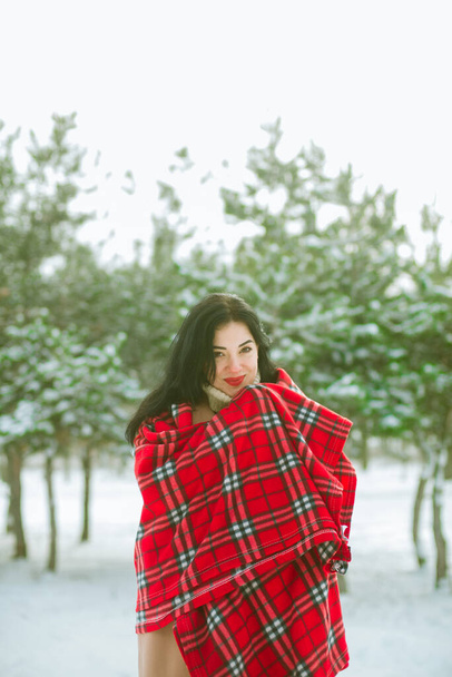 Young cute girl with durk hair in red scarf has fun in snowy weather in winter in the park. Life style  - Foto, Imagem