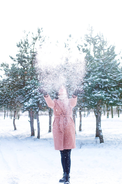 Young cute girl with durk hair has fun in snowy weather in winter in the park. Life style  - Foto, Imagen