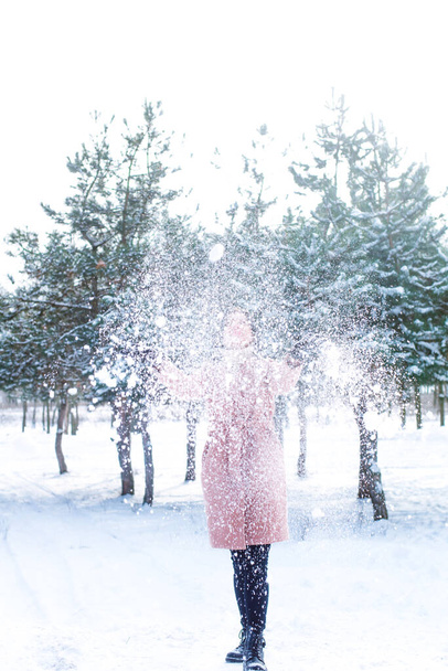 Young cute girl with durk hair has fun in snowy weather in winter in the park. Life style  - Photo, Image