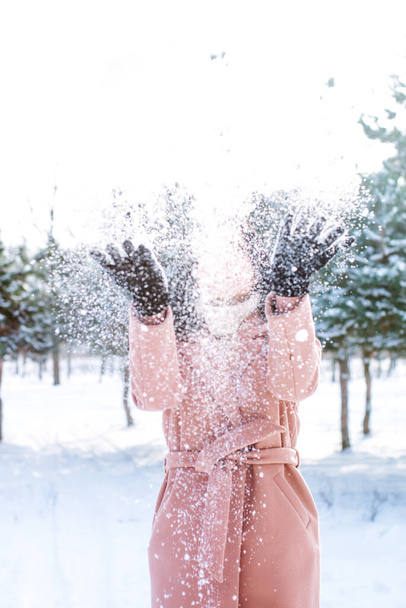 Young cute girl with durk hair has fun in snowy weather in winter in the park. Life style  - 写真・画像