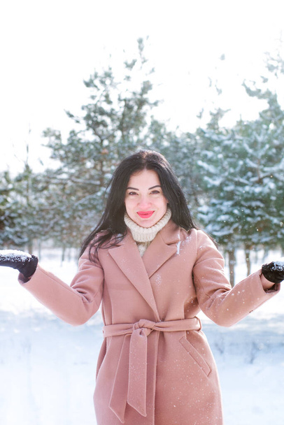 Young cute girl with durk hair has fun in snowy weather in winter in the park. Life style  - Photo, image