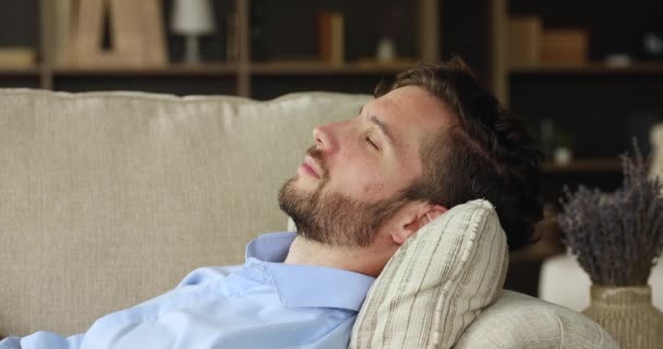 Closeup calm young man close eyes sleep on cozy sofa - Záběry, video