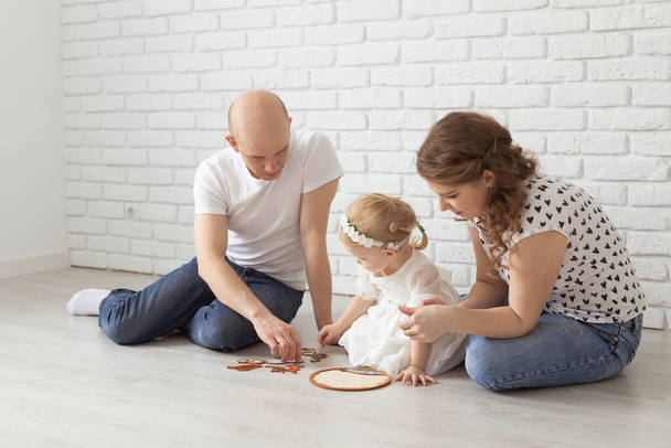 Baby child with hearing aids and cochlear implants plays with parents on floor. Deaf and rehabilitation concept - Fotoğraf, Görsel