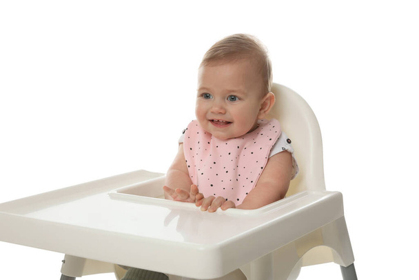 Cute little baby wearing bib in highchair on white background - Фото, изображение