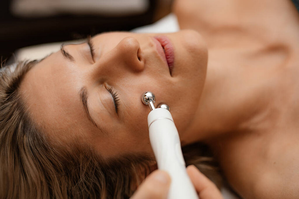 Kadın güzellik terapisi spa detoksu yapıyor. Bağlanma cihazı Hydra Yüz bakımı makinesi. Yaş önleyici cilt kırışıklığı - Fotoğraf, Görsel