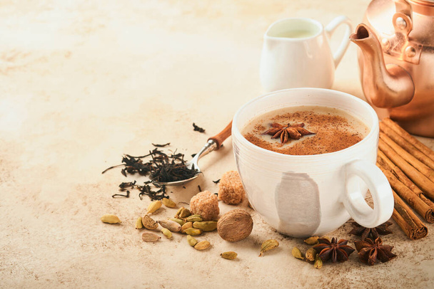 Masala tea. Masala chai spiced tea with milk and spices on light warm beige background. Traditional indian drink. Copy space. Selective focus. - Photo, image