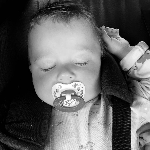 Bebé durmiente con chupete infantil posando fotógrafo para foto en color, cuadro que consta de bebé durmiente apagado chupete infantil, cara de expresión de sonrisa, bebé durmiente saludable en chupete infantil - Foto, Imagen
