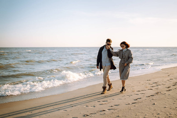 Stylish couple walking and hugging by the sea. Springtime. Relaxation, youth, love, lifestyle solitude with nature. - Fotografie, Obrázek