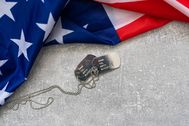 Exército Dog tag token com balas de 9mm e pistola mentira na bandeira dobrada dos Estados Unidos
 - Foto, Imagem