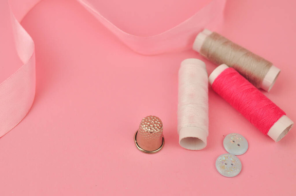 Zařízení pro šití na růžové pozadí kopírovací prostor. Kvalitní fotografie - Fotografie, Obrázek